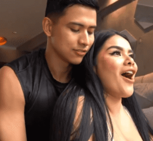 She is stopping him but he isn't